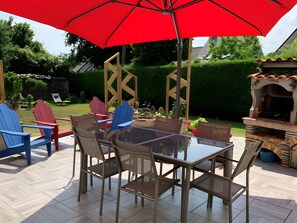 An outdoor patio with a glass table, chairs, and a red umbrella. - Guest Room “L’hermine Blanche” with Wi-Fi (Calorguen)