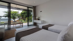 Habitación de hotel moderna con dos camas, un escritorio y un balcón con vistas al exterior.