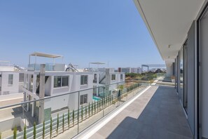 A modern building with a balcony overlooking a residential area. - Luxury 5 Star Cottage – Prime Protaras 1047 (Famagusta)