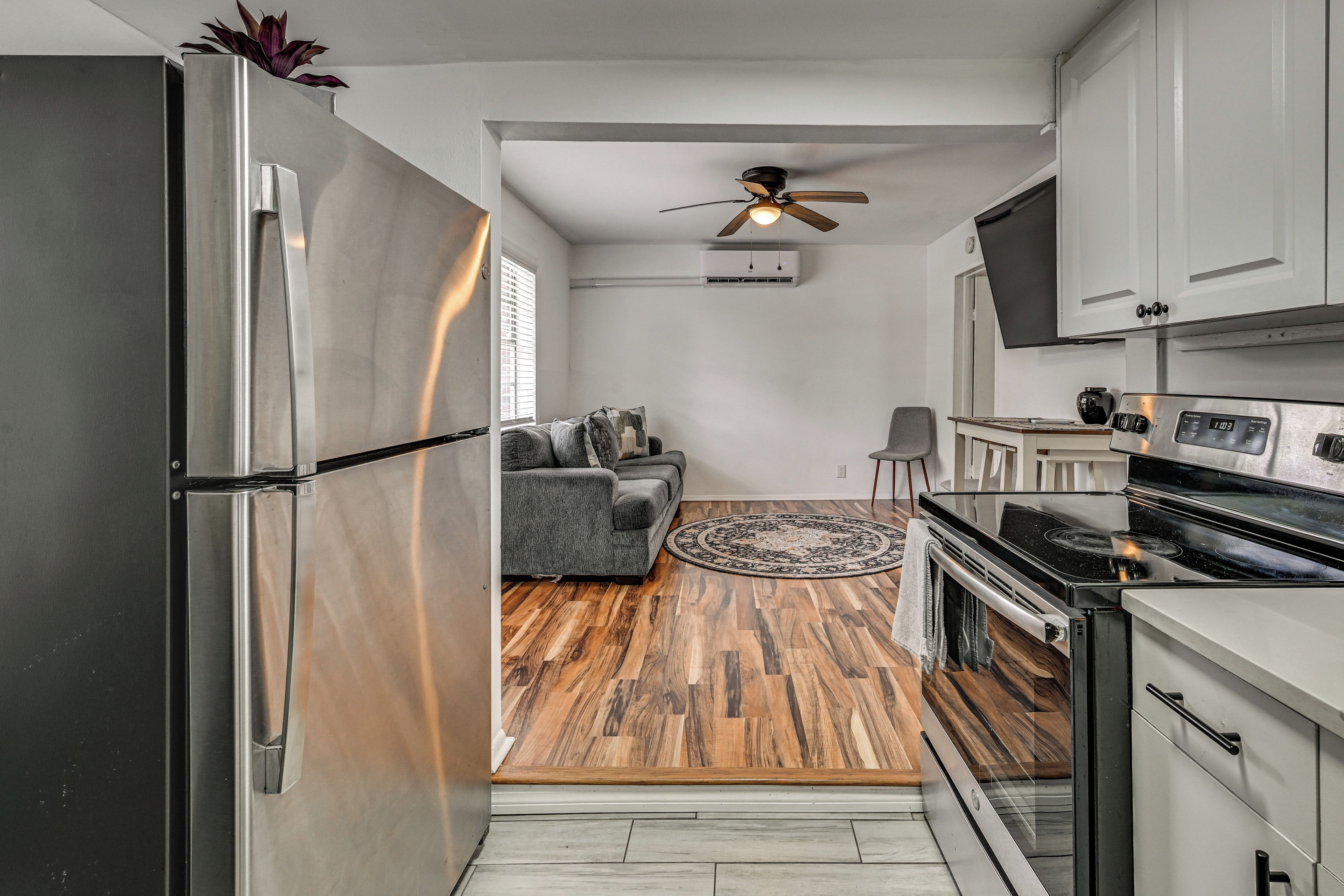 Una cucina compatta con frigorifero, fornello e ventilatore a soffitto.
