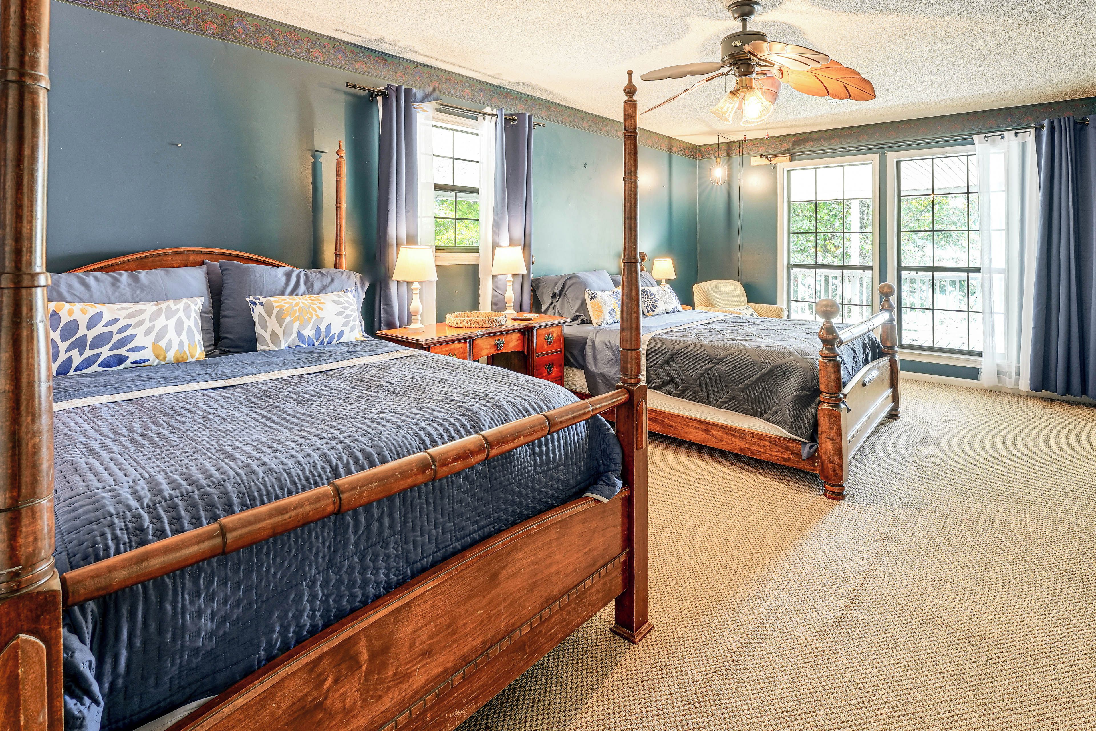 A four-poster bed with a wooden frame and a dark blue quilt.
