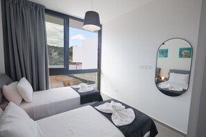 Ein Hotelzimmer mit einem Bett, einem Nachttisch, einem Spiegel und einem Fenster mit Vorhängen.