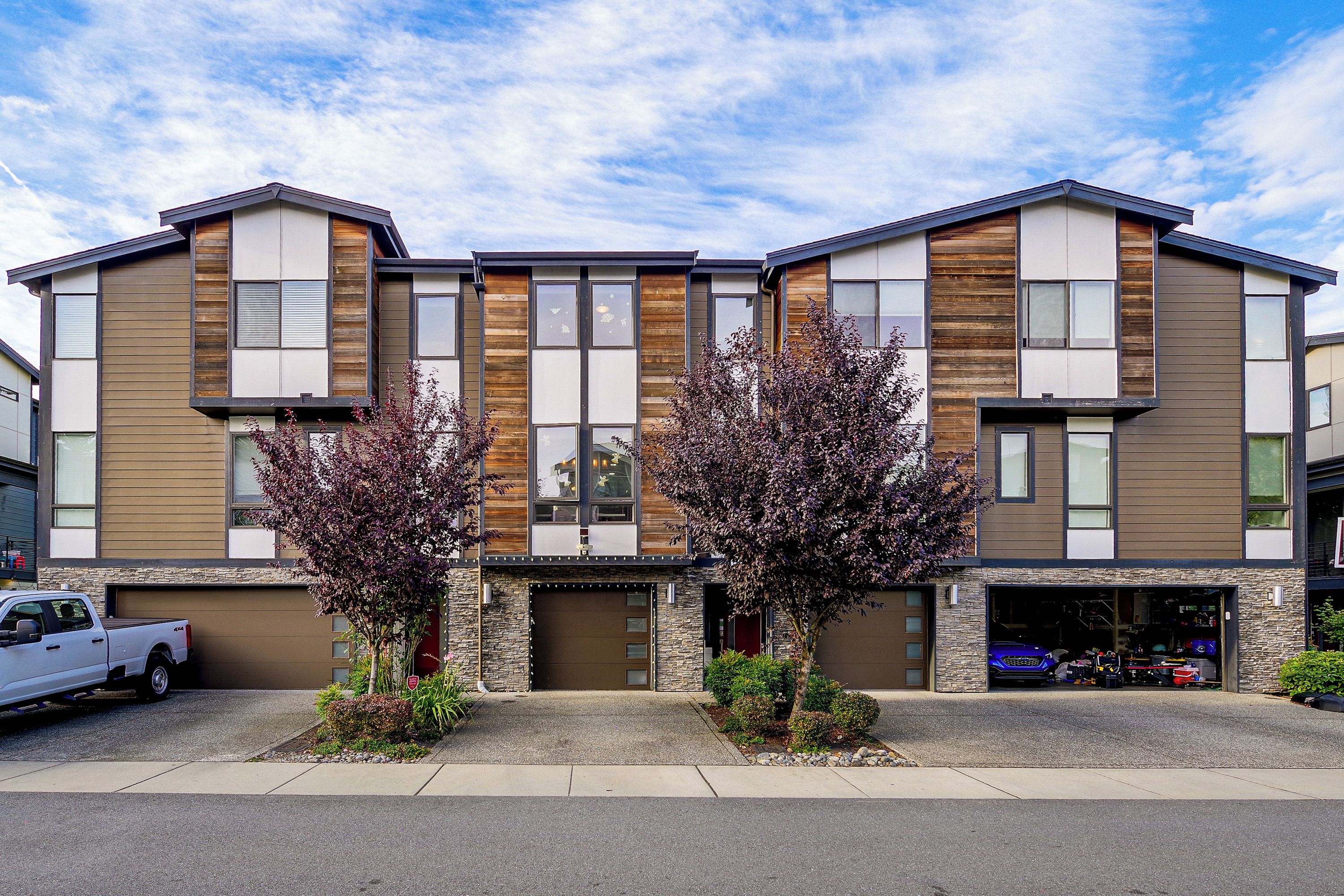 A modern multi-story building with a garage and a driveway.
