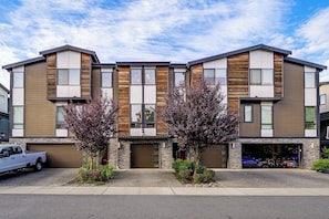 A modern multi-story building with a garage and a driveway. - All-seasons Everett Escape w/ Private Balcony! (Everett)