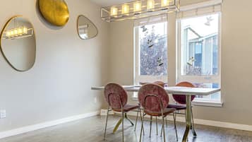 A dining area with a table, chairs, and a chandelier.
