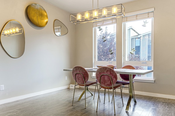 A dining area with a table, chairs, and a chandelier. - All-seasons Everett Escape w/ Private Balcony! (Everett)