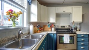 A kitchen with a double sink, a stove, and a refrigerator.