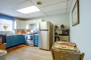 A kitchen with a refrigerator, stove, oven, and coffee maker.
