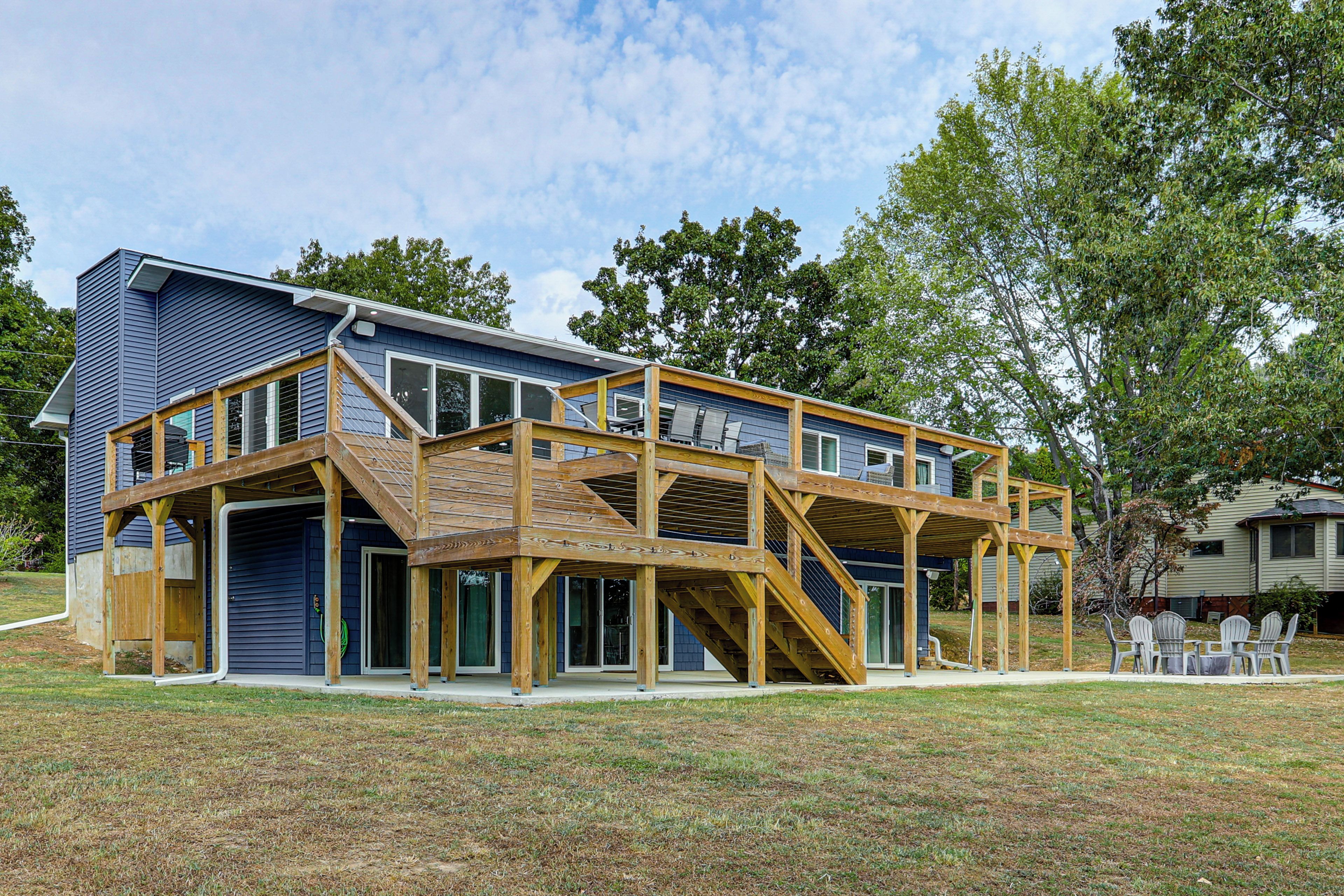 A two-story house with a wooden deck and a covered porch.