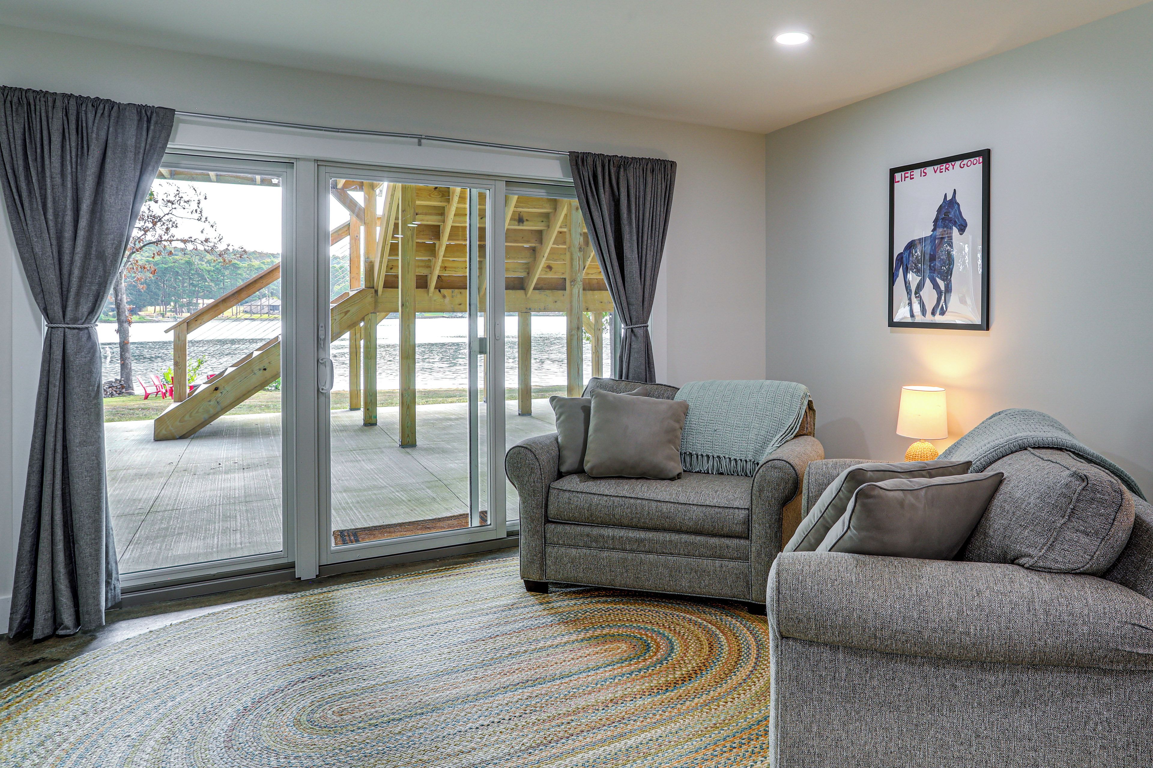 A living room with a sofa, a rug, and a painting of a horse on the wall.