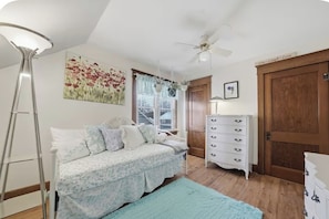 A bedroom with a bed, a dresser, a ceiling fan, and a window with blinds. - Near Lake Erie Beaches! Angola Gem w/ Patios (Angola)