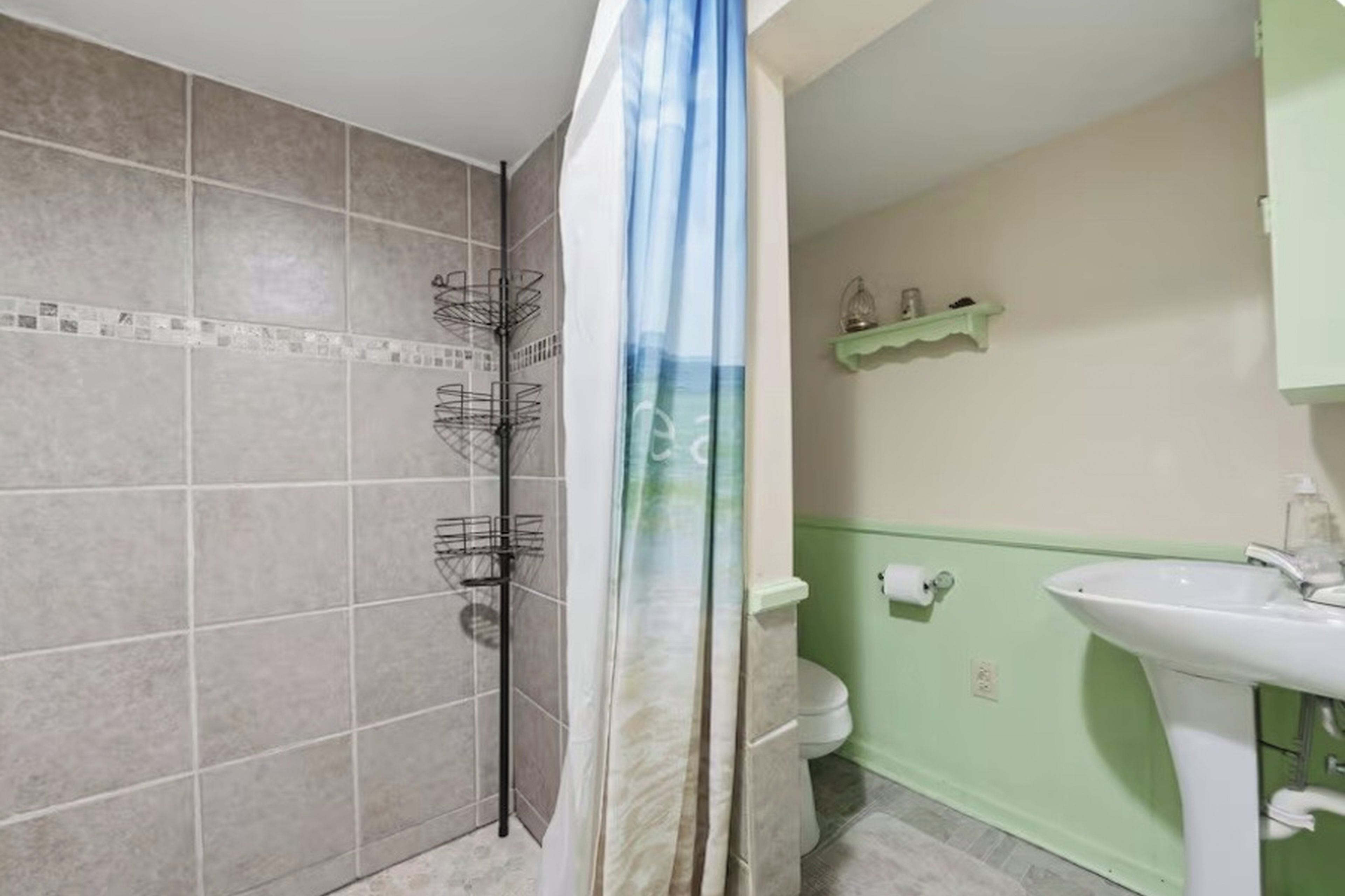 A bathroom with a shower, toilet, and sink.