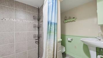 A bathroom with a shower, toilet, and sink.