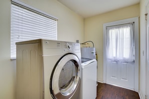 A compact laundry room with a front-loading washing machine, a dryer, and a water heater. - Families w/ Pets Welcome! Retreat 14 Mi to Tampa (Brandon)