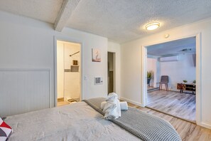 A bedroom with a bed, a bathroom with a shower, and a hallway leading to a living area. - South Tampa Stay w/ Backyard & Fire Pit! (Tampa)