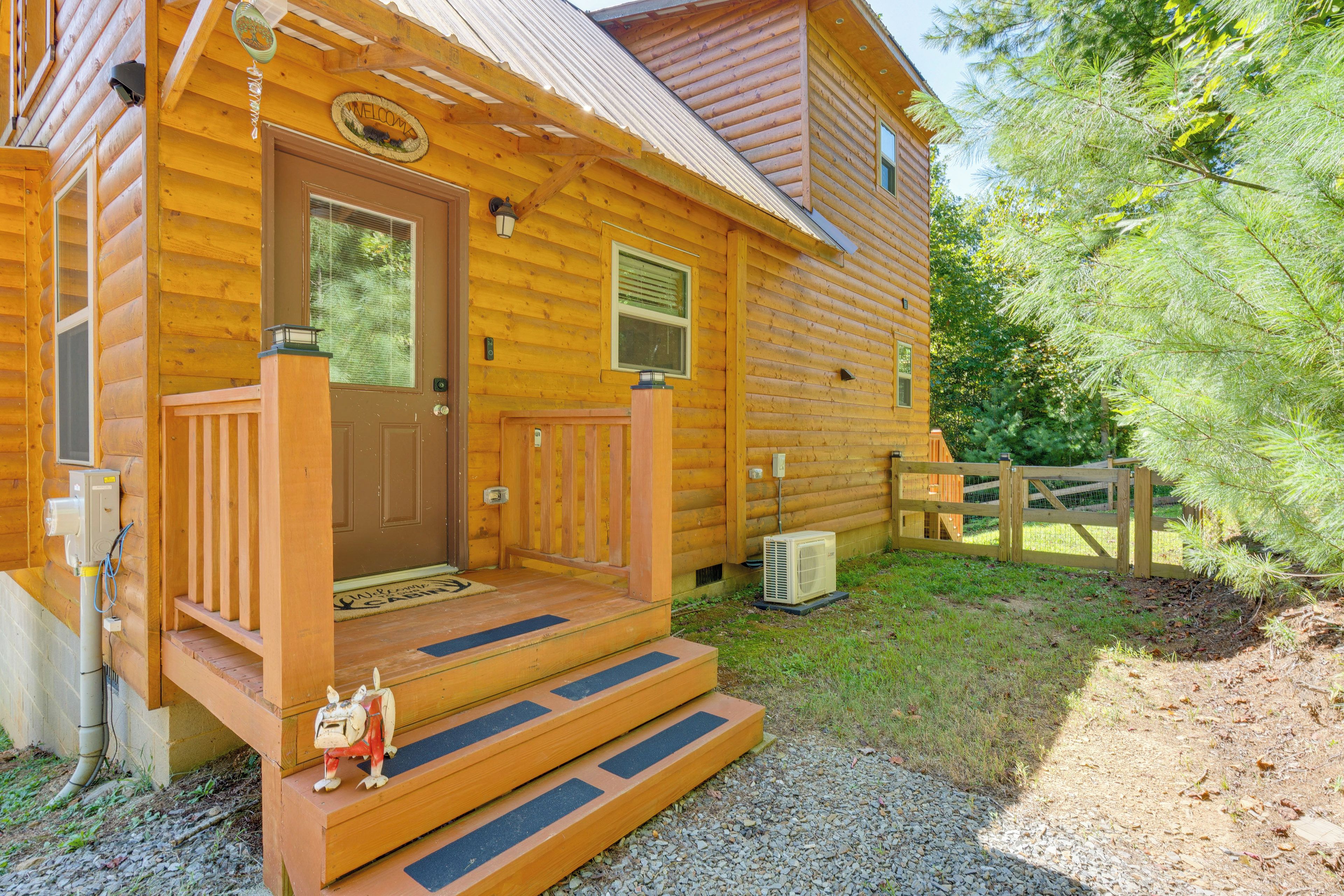 A log cabin with a wooden porch, a front door, and a small step leading to the entrance.