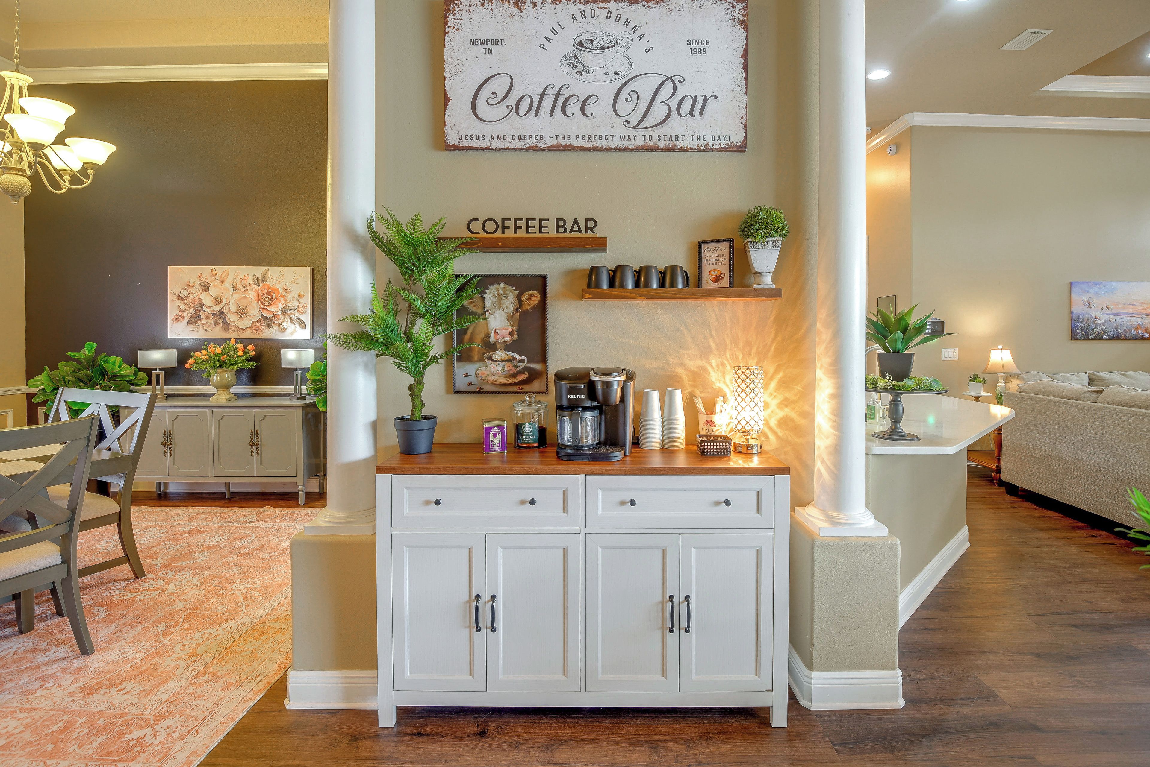 A cozy living room with a coffee bar area, a dining area, and a kitchen.