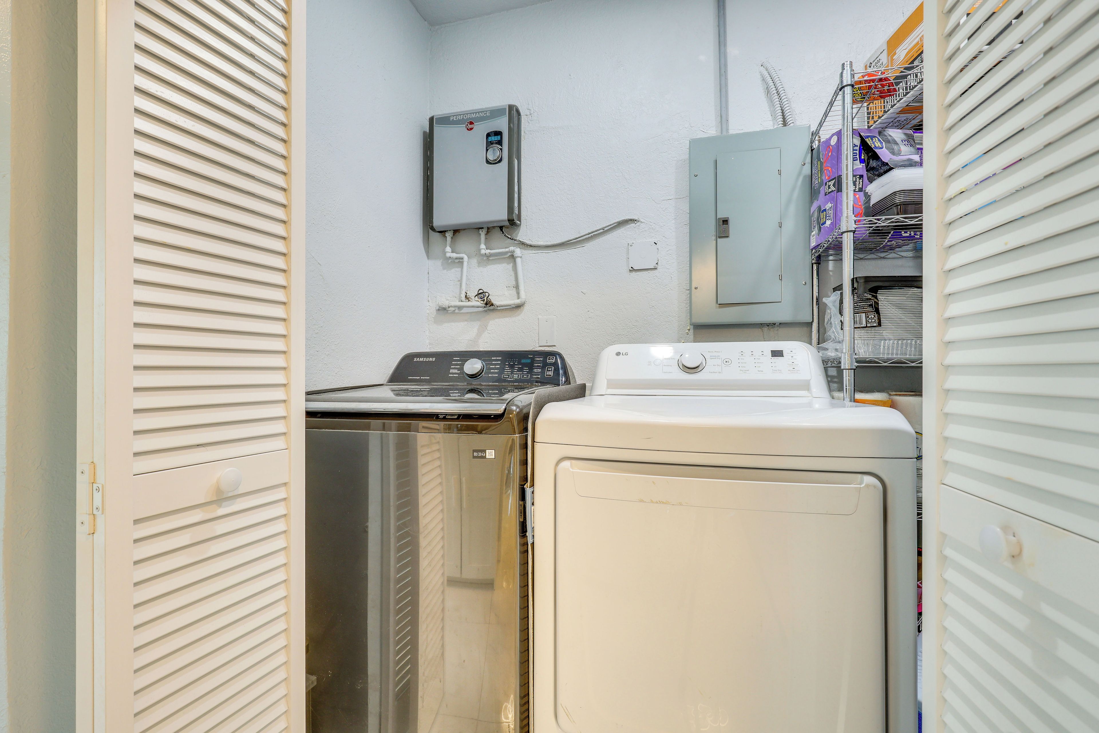 A laundry room with a washing machine, a dryer, and a utility meter on the wall.