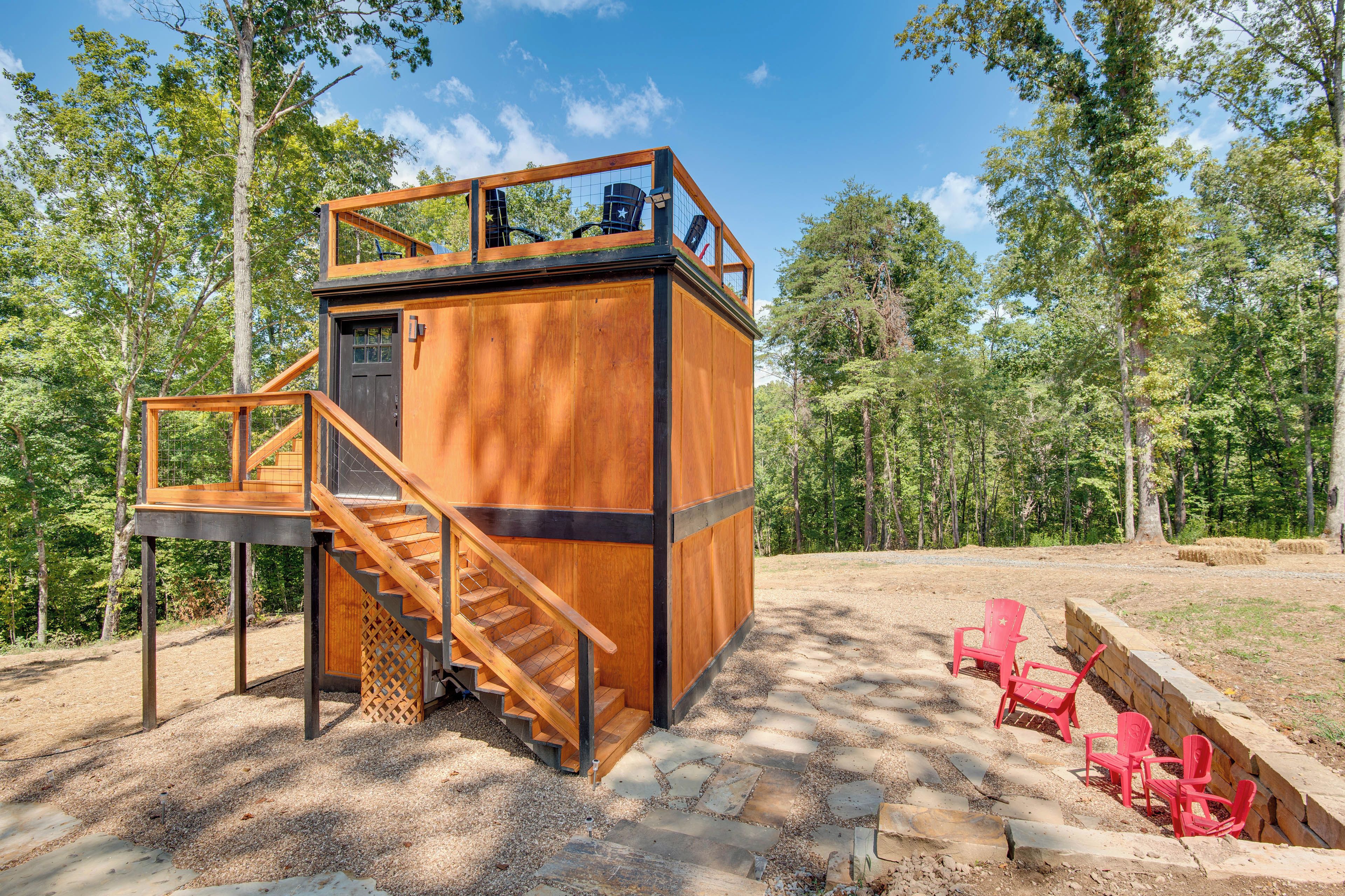 A wooden cabin with a balcony and a staircase leading to a second level.