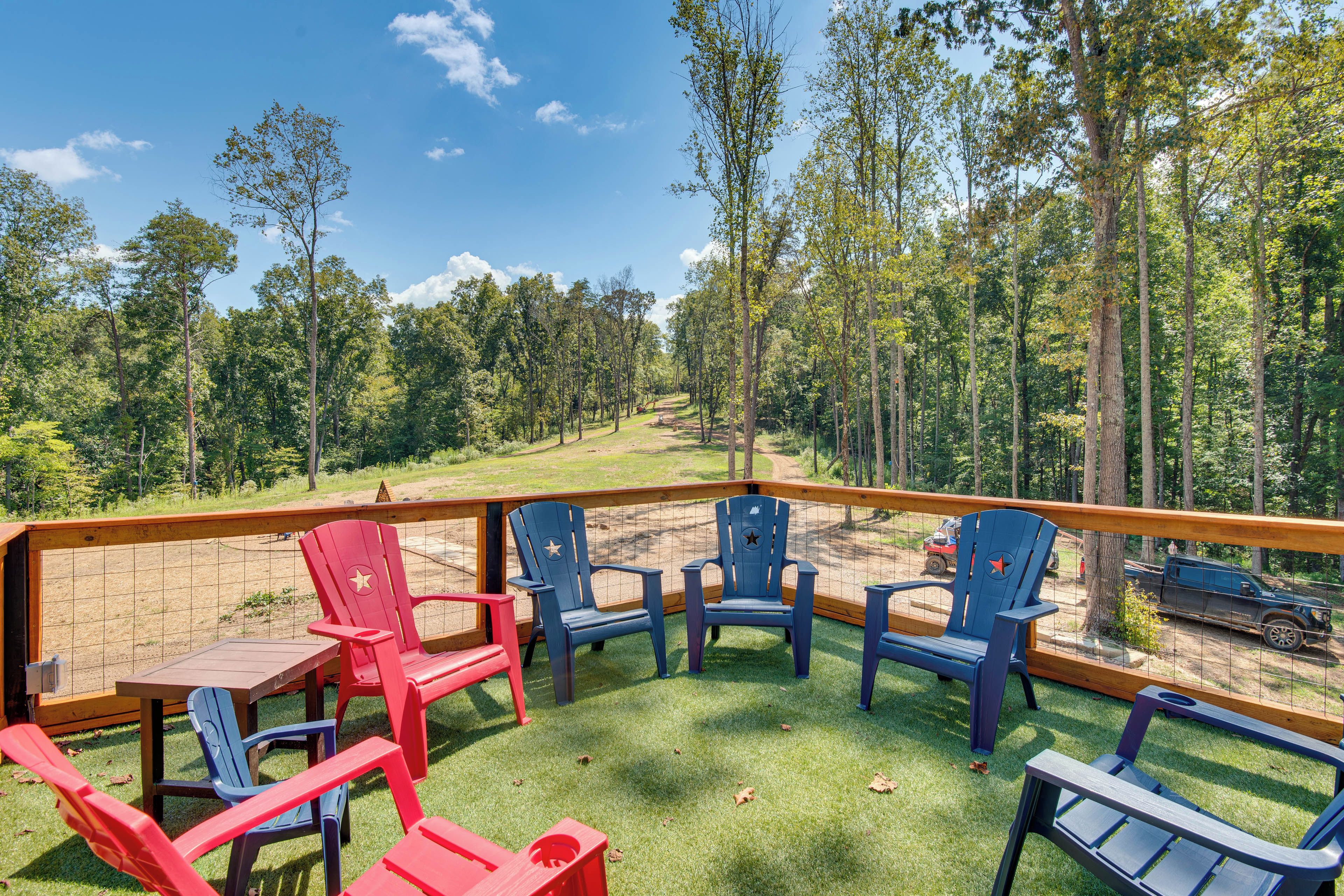 A deck with outdoor seating and a view of a forested area.