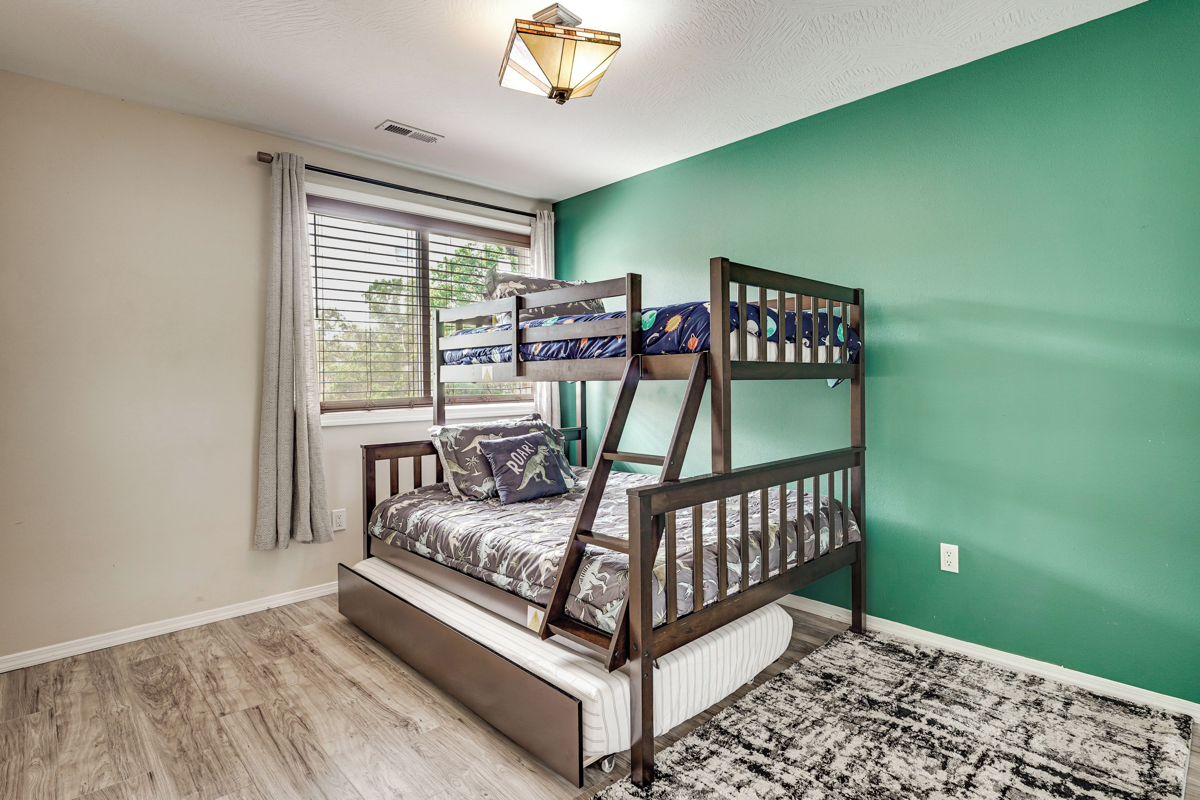 A bunk bed with a window, a radiator, and a patterned rug.