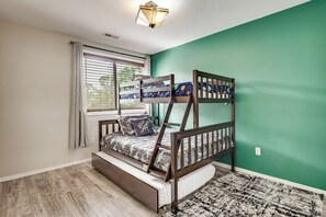 A bunk bed with a window, a radiator, and a patterned rug.