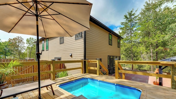 A backyard with a swimming pool, wooden deck, and a house. - Patio, Porch + Fire Pit! Family Home By Branson (Rockaway Beach)