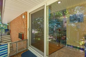 A staircase leading to a balcony with a view of trees and a glass door. - 6 Mi to Uconn Health: Cozy Condo w/ Balcony (Farmington)