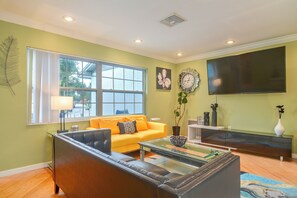 A living room with a sofa, coffee table, and a flat-screen TV. - Hot Tub, Water View! Largo Home 10 Mi to Beaches (Largo)
