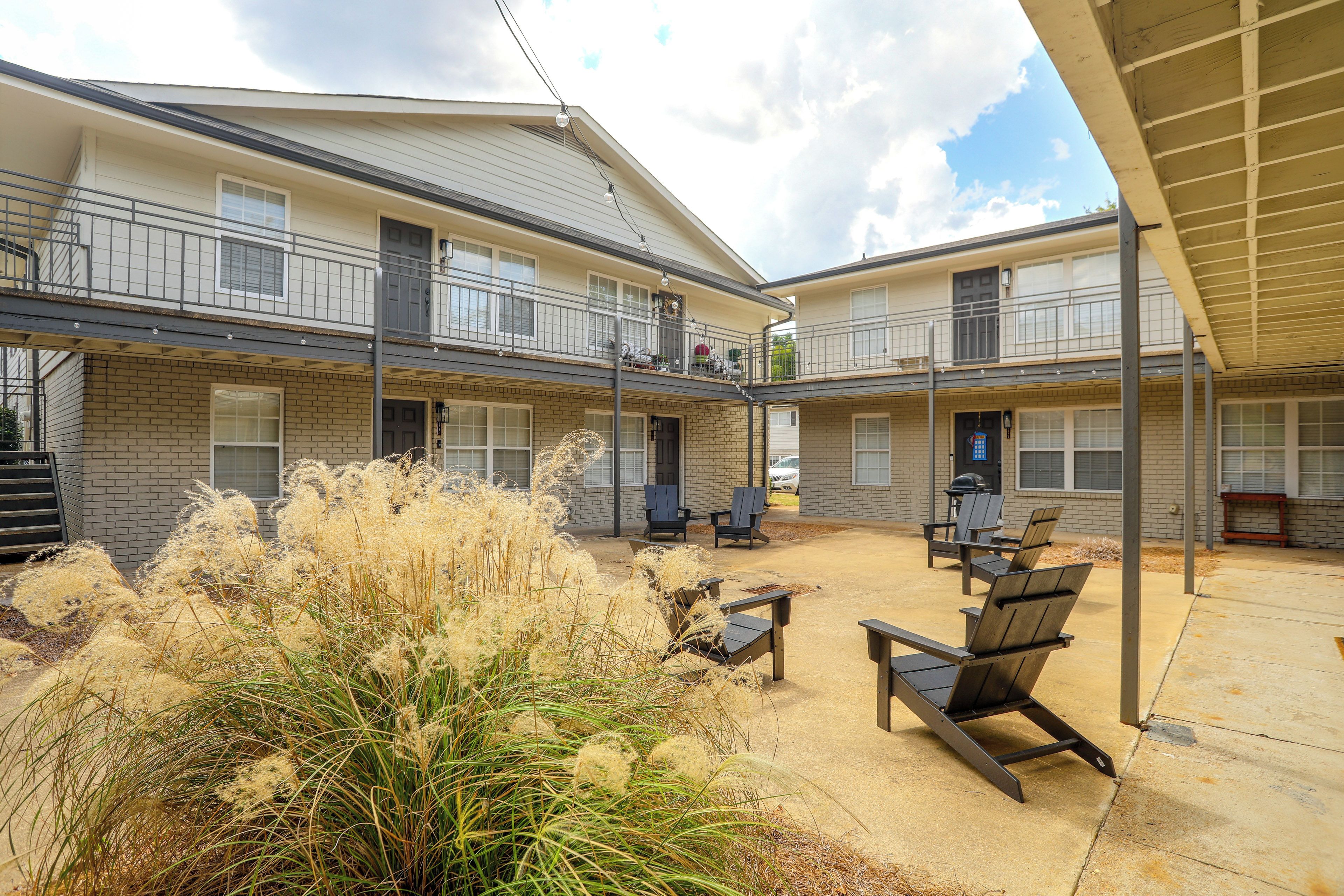 A multi-story building with a covered outdoor patio area featuring outdoor seating and a garden.