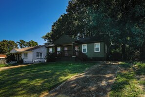A two-story house with a front porch, a small front yard, and a large tree. - Near Midtown Attractions! Memphis Duplex (Memphis)