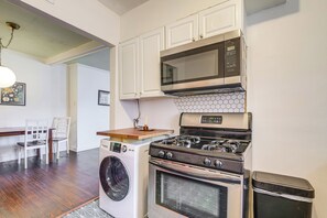 A compact kitchen with a microwave, stove, and washing machine. - Near Midtown Attractions! Memphis Duplex (Memphis)