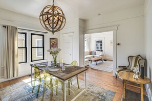 A dining area with a wooden table, chairs, and a chandelier. - Private Deck + Yard: Downtown San Jose Home (San Jose)