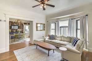A living room with a sofa, coffee table, and a ceiling fan. - Private Deck + Yard: Downtown San Jose Home (San Jose)