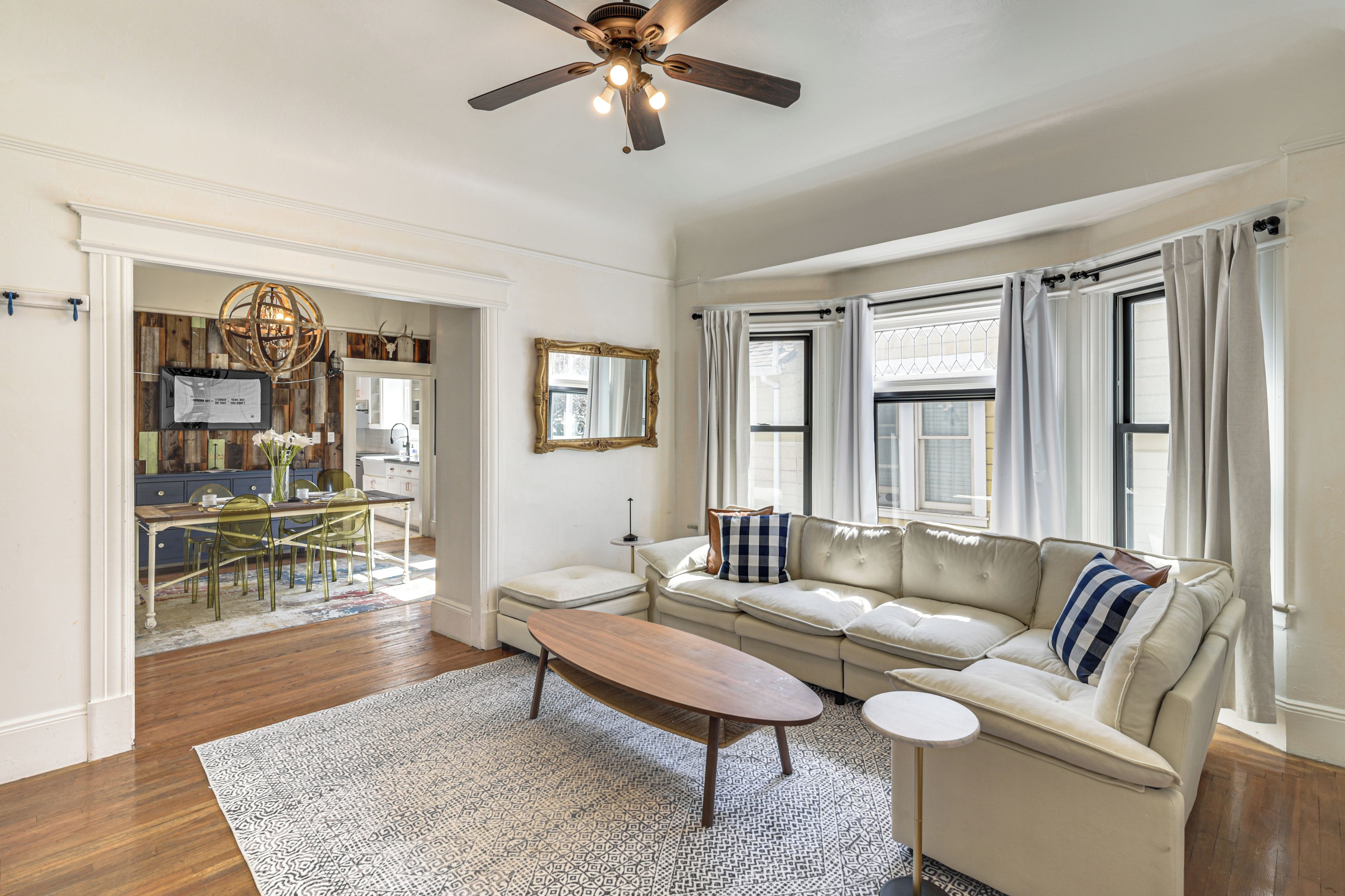 A living room with a sofa, coffee table, and a ceiling fan.