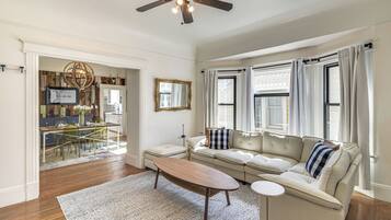 A living room with a sofa, coffee table, and a ceiling fan.