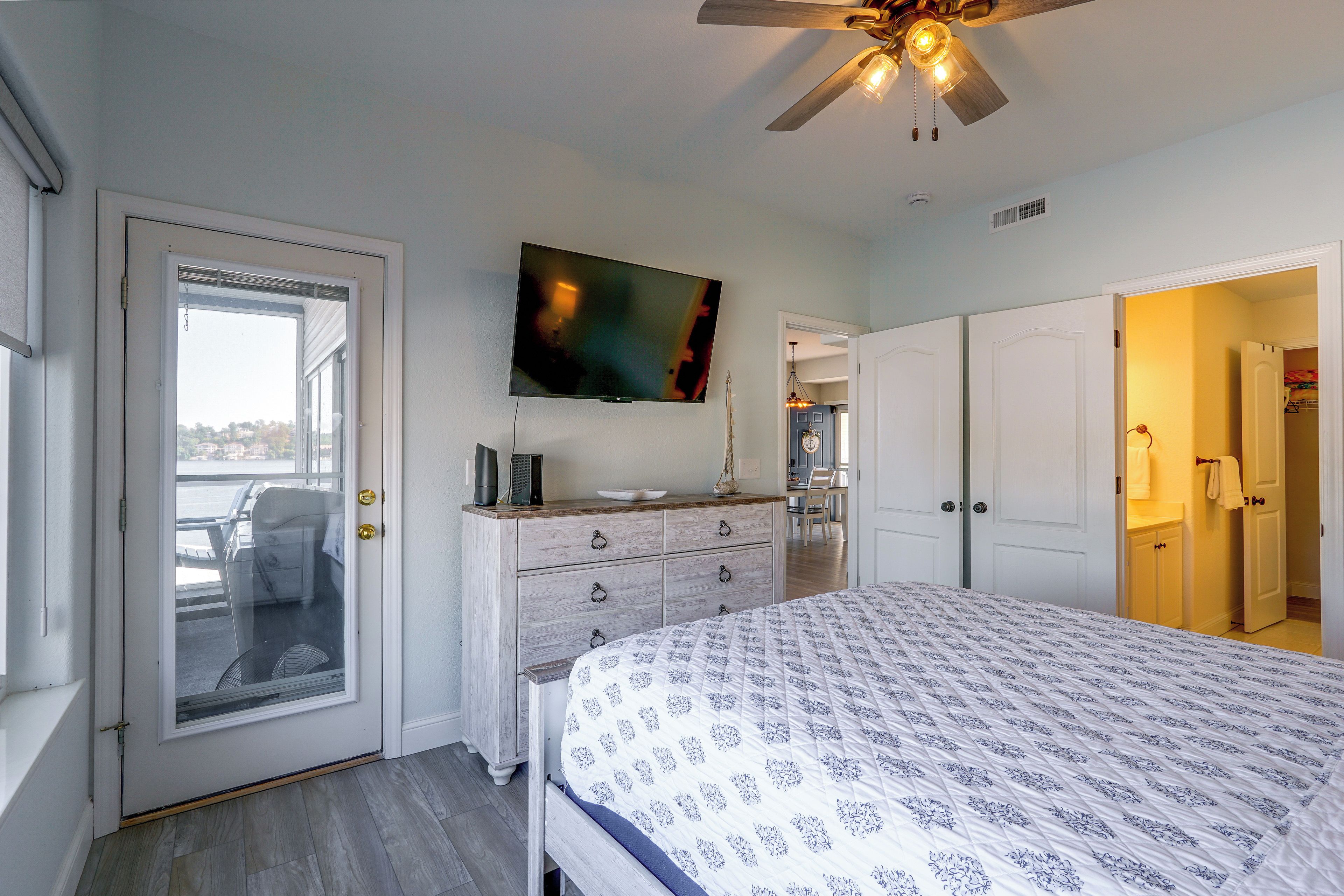 A bedroom with a bed, dresser, and a ceiling fan.