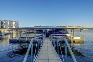 A marina with boats docked, a covered walkway, and buildings in the background. - Pool Access! Family Getaway on Lake of the Ozarks (Lake Ozark)