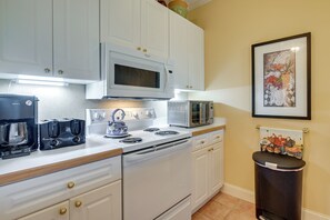 A modern kitchen with white cabinetry, a built-in microwave, a toaster, and a kettle. - 1 Mi to Beach! Golfers Paradise on Pawleys Island (Pawleys Island)