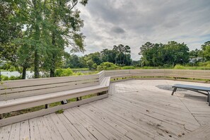 A wooden deck with benches, surrounded by lush greenery and trees. - 1 Mi to Beach! Golfers Paradise on Pawleys Island (Pawleys Island)