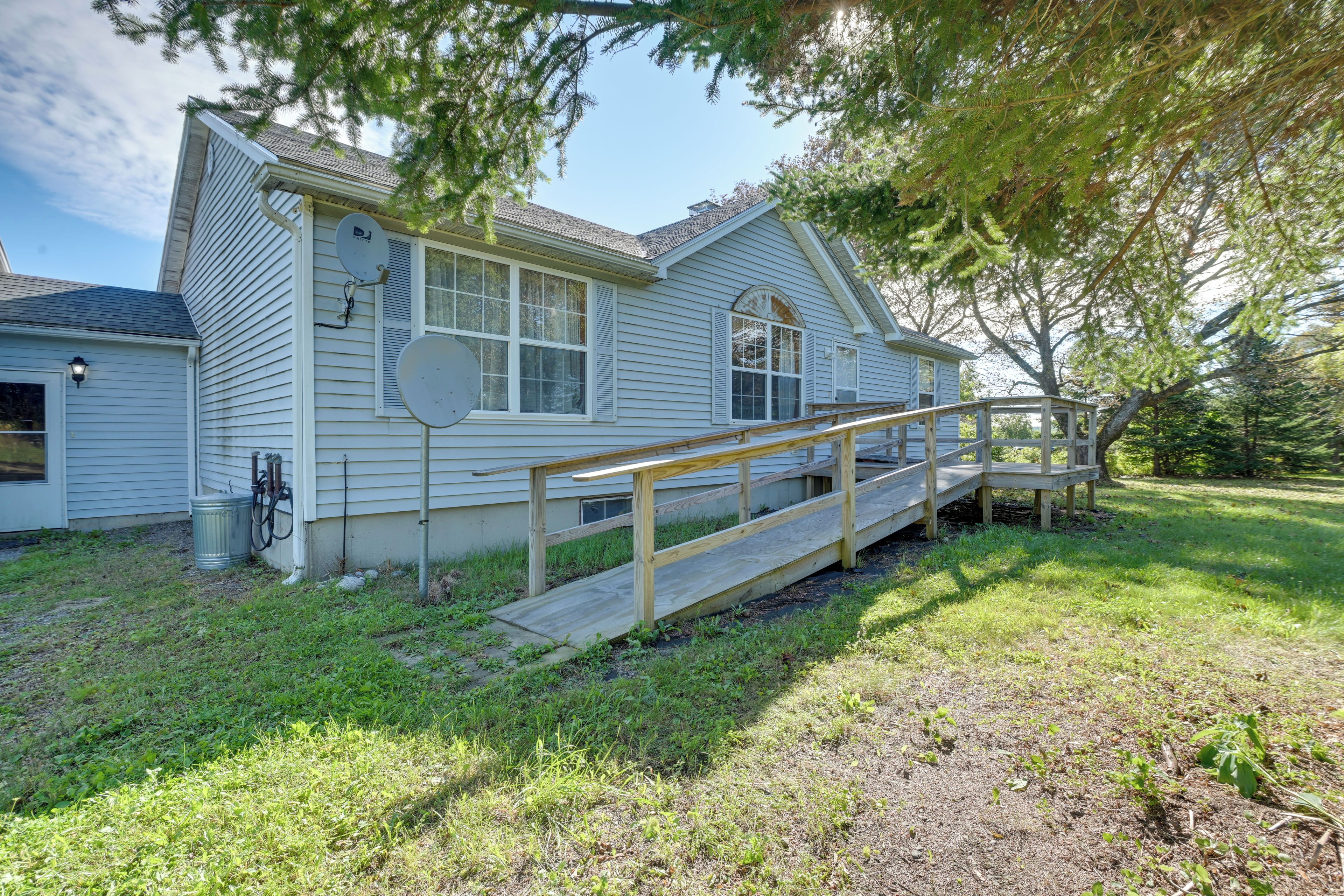 A single-story house with a wooden deck and a ramp leading to the front door.