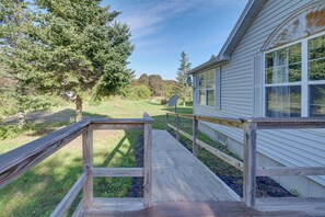 A wooden deck leading to a house with a satellite dish and a large tree in the background. - 21 Acres, Near Trails to Shore With Island Access (Lubec)