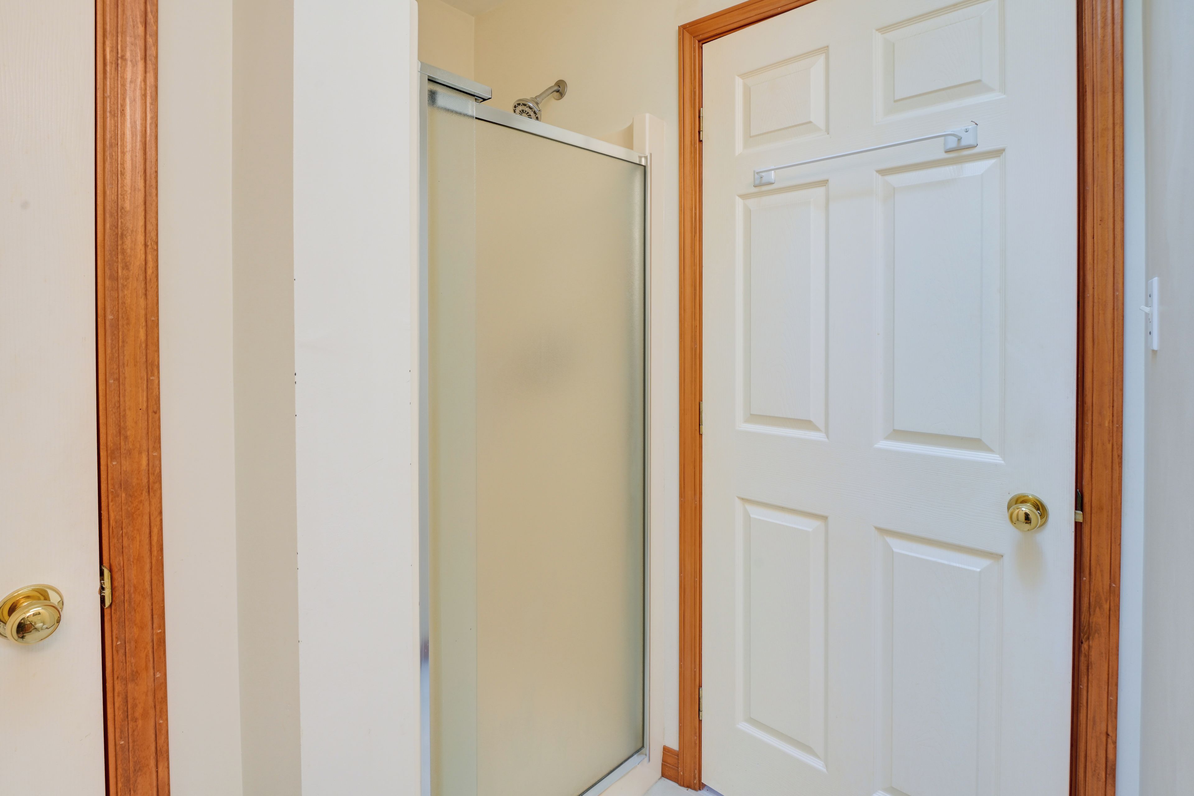 Une porte blanche fermée, dotée d’une poignée de porte en laiton et d’un cadre en bois.