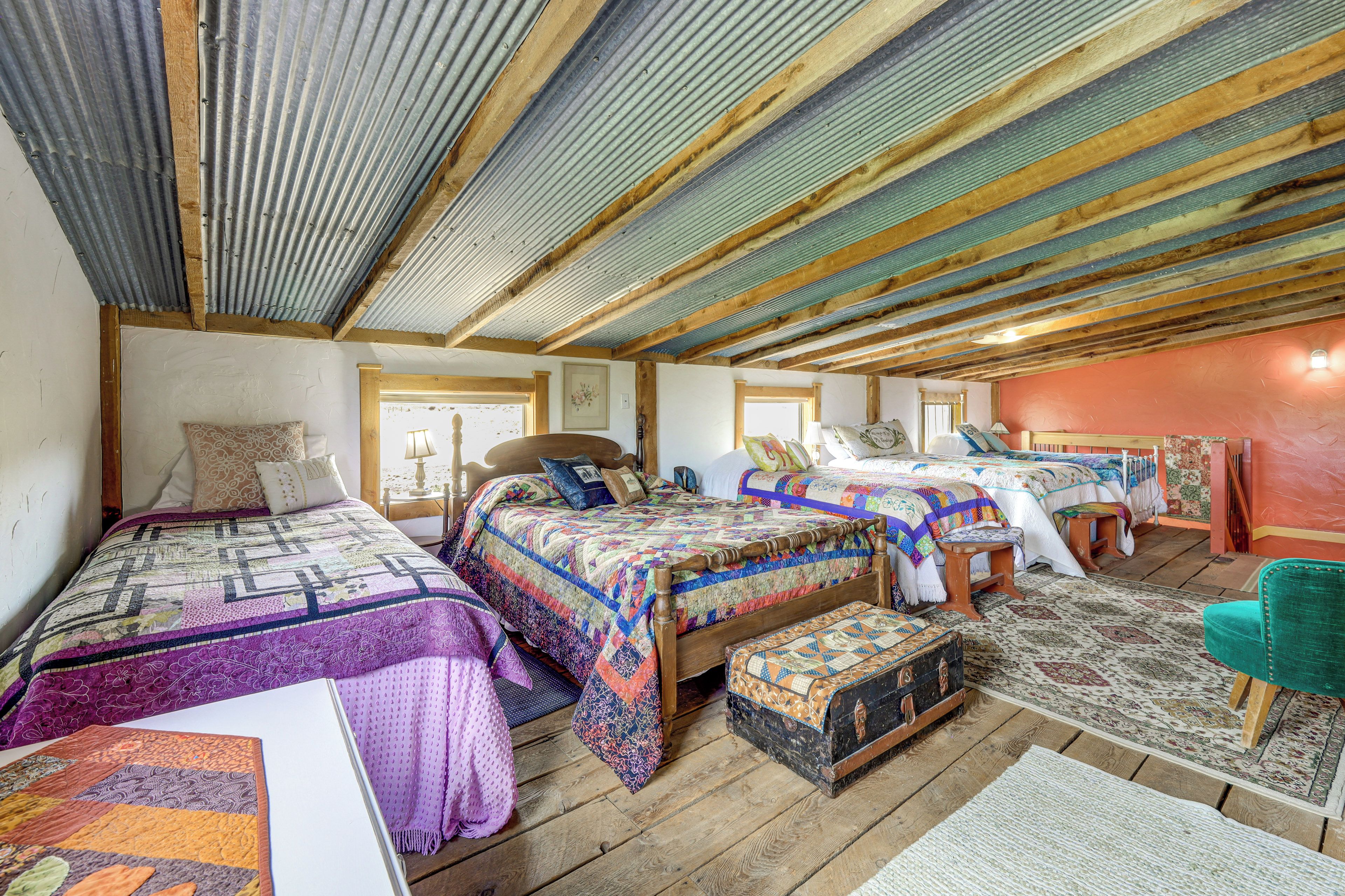 A cozy, rustic bedroom with two beds, a wooden bench, and a small table.
