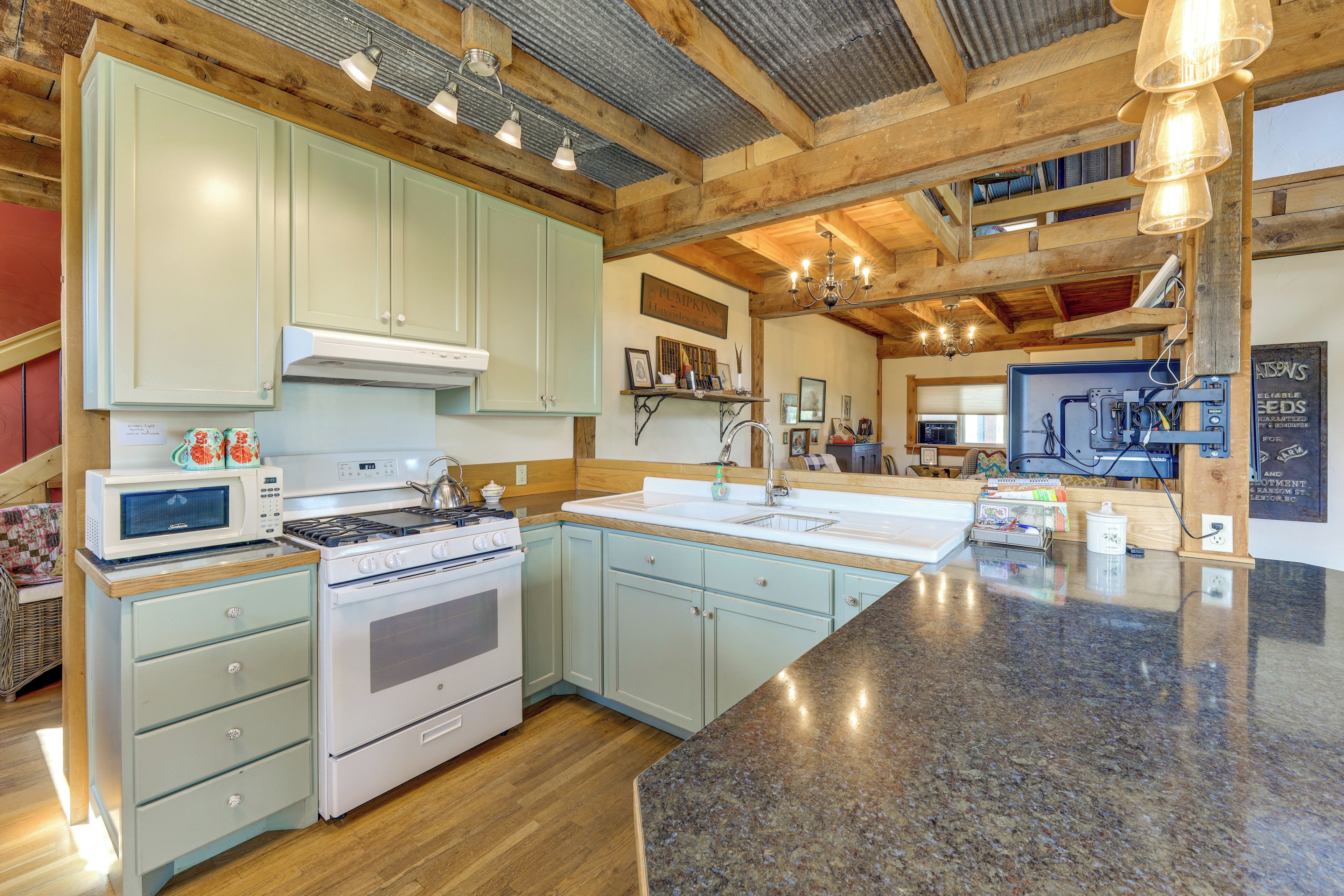 A spacious kitchen with a large island, wooden beams, and a variety of appliances.
