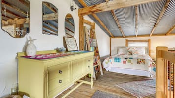 Un dormitorio acogedor con una cama de madera, un aparador amarillo y un espejo en la pared.