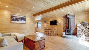 Een houten interieur met een open haard, een televisie en een gezellige zithoek.