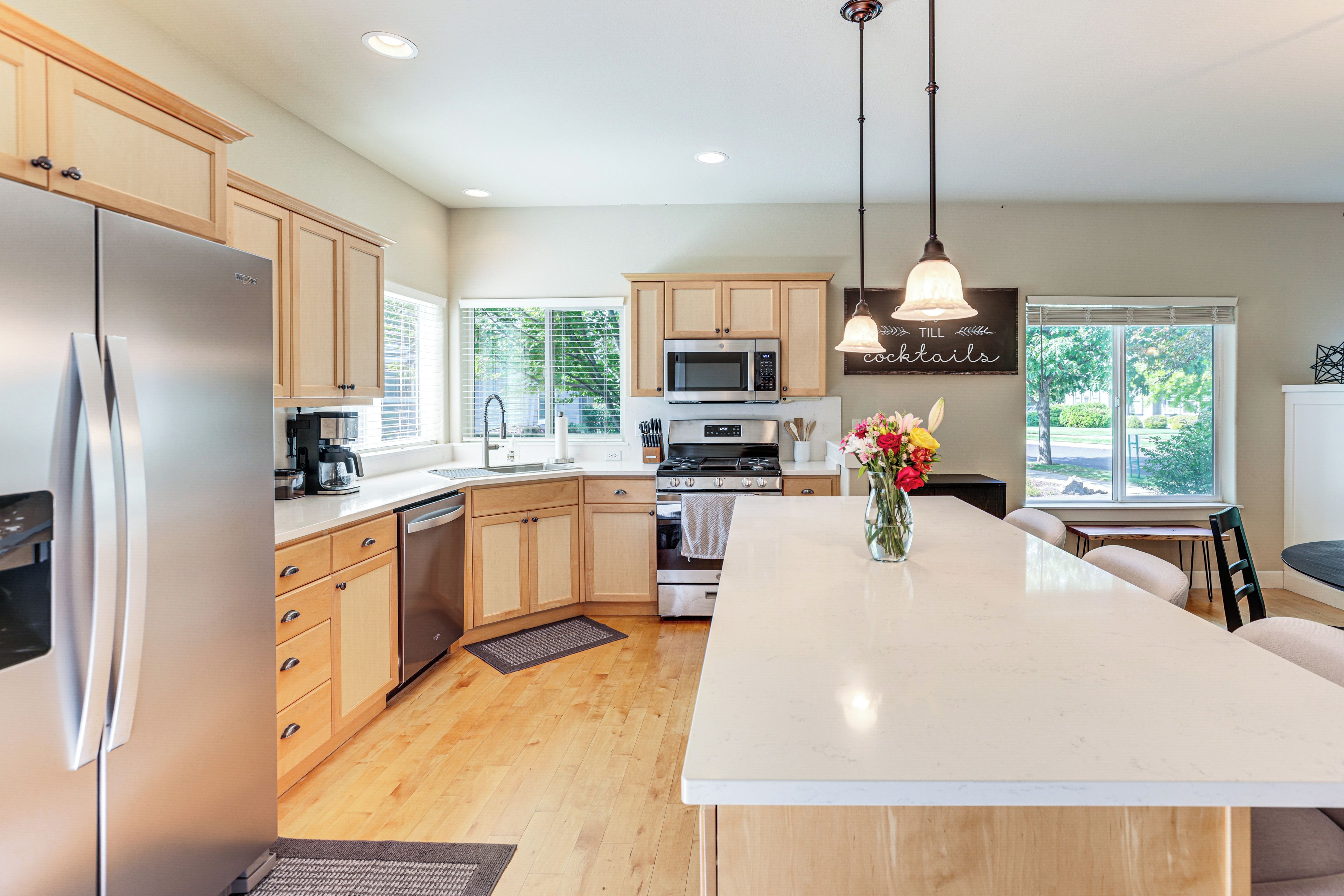 A modern kitchen with wooden cabinets, stainless steel appliances, and a central island.