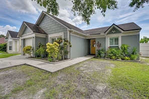 A two-story residential house with a grey exterior, a front porch, and a well-maintained lawn. - Families w/ Pets! Home 10 Mi to Busch Gardens (Tampa)