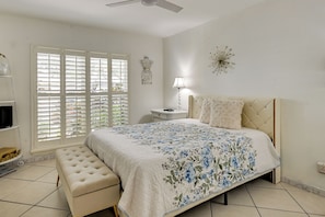 A bedroom with a bed, a nightstand, a lamp, a bench, and a window with blinds. - Families w/ Pets! Home 10 Mi to Busch Gardens (Tampa)